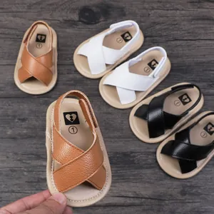 Close-up of baby leather sandals with cross straps for summer pre-walking