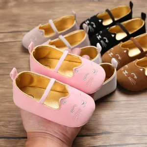 Close-up of pink baby walking shoes featuring adorable cartoon cat embroidery and soft sole