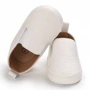 Dettaglio di scarpe primi passi bianche testurizzate con suola morbida per neonati 0-12 mesi.