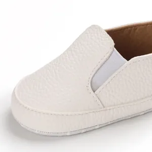 Dettaglio ravvicinato di scarpine primi passi in pelle bianca con inserto elastico