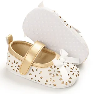Detailansicht der weißen Baby-Prinzessinenschuhe mit Goldrand und rutschfester Sohle
