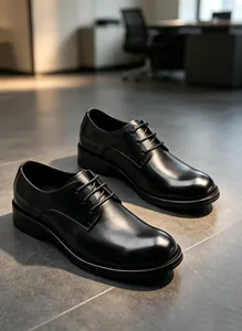 Detailansicht klassischer schwarzer Herren-Business-Lederschuhe im modernen Büro.