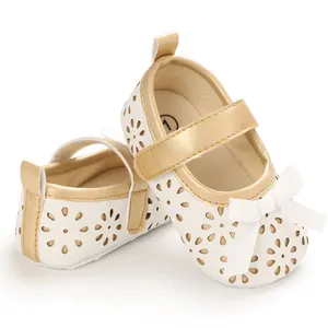 Seiten- und Frontansicht von weißen Baby-Mädchen-Schuhen mit Goldrand und Blumenmuster