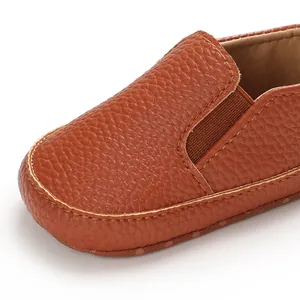 Dettaglio scarpe da bambino in pelle marrone con suola morbida antiscivolo per neonati