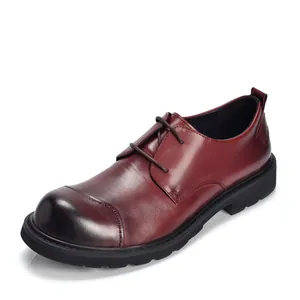 Macrodetail van een bordeauxrode herenleren Oxfordschoen met handgestikte ronde neus.