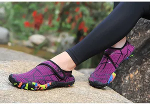 Detail von lila Schnelltrocknenden Badeschuhen mit geometrischem Muster auf Fels