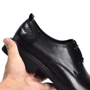 Detailopname van hoogwaardige zwarte leren herenschoenen met veters en dikke zool.
