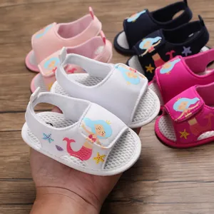 Primer plano de sandalia blanca para bebé con diseño de sirena y suela de malla suave
