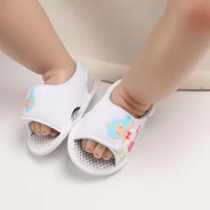 Detalle de sandalias blancas para bebé con diseño de sirena y suela de malla suave