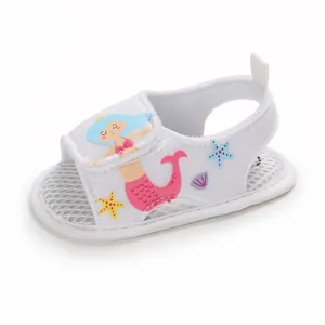 Primer plano de sandalia blanca para bebé con dibujo de sirena y suela de malla