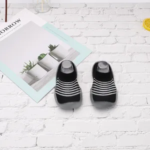 Primer plano de zapatos de punto para bebé a rayas blancas y negras con suela de goma