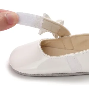 Nahaufnahme weißer Baby-Prinzessinenschuh mit verstellbarem Klettverschluss-Detail
