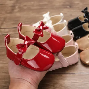Nahaufnahme roter glänzender Baby-Prinzessinenschuhe aus PU mit Schleifen und Farbauswahl