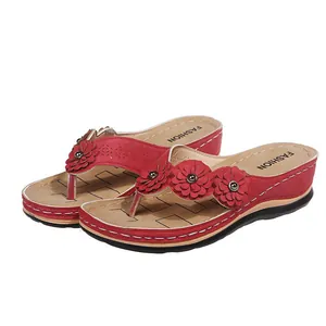 Chanclas rojas con cuña, decoradas con tres flores 3D y detalles calados con láser.