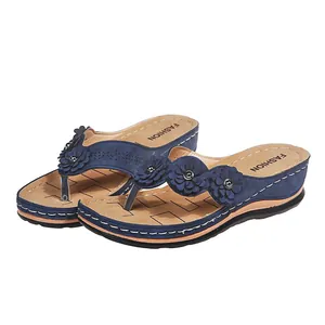 Vista de detalle de sandalias de cuña azules con flores cortadas con láser y plantilla beige
