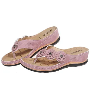 Vista detallada de chanclas con cuña rosa con flores y motivos cortados con láser