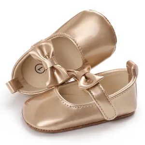 Nahaufnahme goldener PU-Leder Baby Lauflernschuhe mit Schleife und weicher Sohle