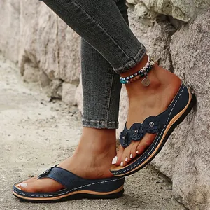 Vista detallada de sandalias de cuña azules con patrones láser y flores decorativas