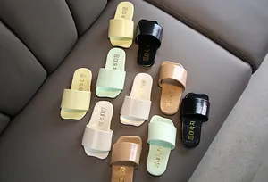 Varios colores de sandalias de verano para niños dispuestas sobre una superficie gris