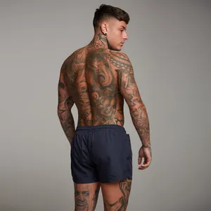 Rear view of men's navy blue gym shorts featuring zipper pockets on muscular model