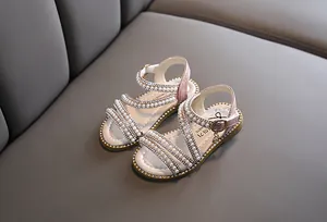 Nahaufnahme von rosa Prinzessinnensandalen für Mädchen mit eleganten Perlen und Strass