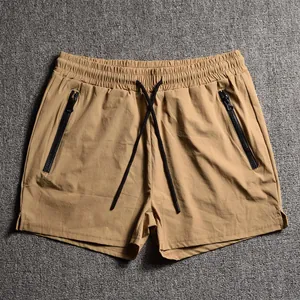 Detail view of men's khaki sports shorts with black zipper pockets and drawstring