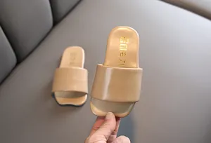 Primer plano de pantuflas infantiles de cuero beige de estilo coreano