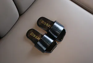 Primer plano de sandalias negras para niños con elegante texto coreano dorado