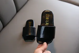 Primer plano de sandalias negras para niños estilo coreano con plantilla dorada