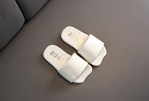 Detalle superior de chanclas infantiles color blanco roto con texto coreano en plantilla