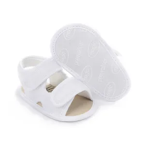 Close-up detail of white breathable mesh baby sandals with double velcro straps