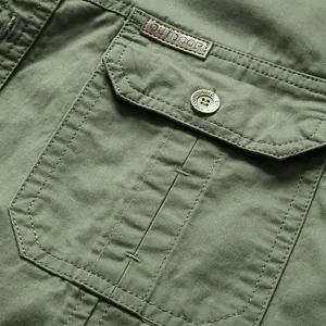 Close-up of a men's green cotton cargo shirt pocket featuring an Outdoor leather patch