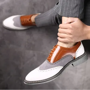 Gros plan de chaussures richelieu bicolores pour hommes en daim gris et cuir marron
