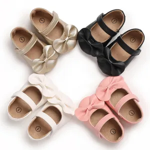 Détail des chaussures de princesse pour bébé en or, noir, blanc et rose, semelle souple.