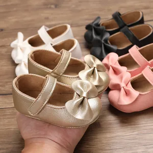 Vue détaillée de chaussures Mary Jane dorées pour bébé avec un détail de nœud chic