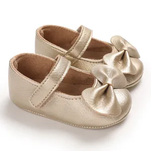 Vue détaillée de chaussures dorées pour bébés filles avec nœud décoratif et bride