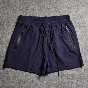 High-quality detailed view of men's sports shorts with elastic waist and zipper pockets