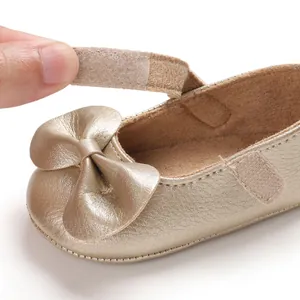 Gros plan de chaussure bébé fille avec nœud et sangle à scratch ajustable