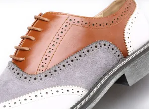 Gros plan d'une chaussure Brogue tricolore avec perforations et détails en daim doux
