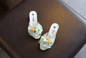 Detailed view of girls' princess high-heeled slippers with mesh bow and heart