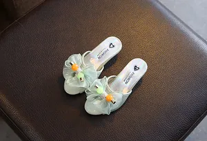 Detailed view of girls' mint green slippers with a large bow and colorful beads.