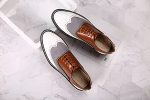Vue de dessus détaillée de chaussures richelieu tricolores pour hommes en blanc, gris et brun.