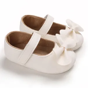 Gros plan de chaussures de princesse blanches pour bébé fille avec un joli nœud doux