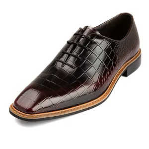 Detail van bordeauxrode formele herenschoenen met elegant leer met krokodillenreliëf