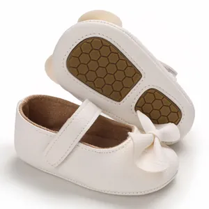 Vue détaillée des chaussures de princesse blanches pour bébé avec nœud et semelle