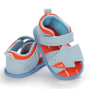 Close-up of cute light blue and orange shark cartoon baby summer walking sandals with velcro