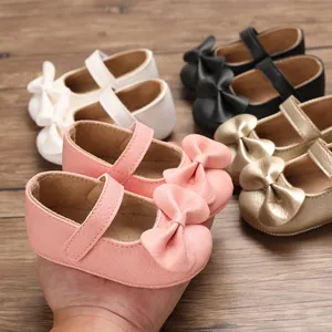 Détail de chaussures de marche princesse pour bébé en rose, or, crème et noir