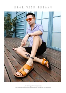 Stijlvolle oranje leren herensandalen met metalen gesp op een houten terrasvloer