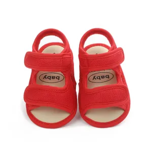 Close-up of red mesh baby sandals with secure velcro straps and soft beige insoles.