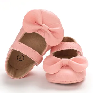 Gros plan de chaussures de princesse roses pour bébé avec semelle souple et nœud